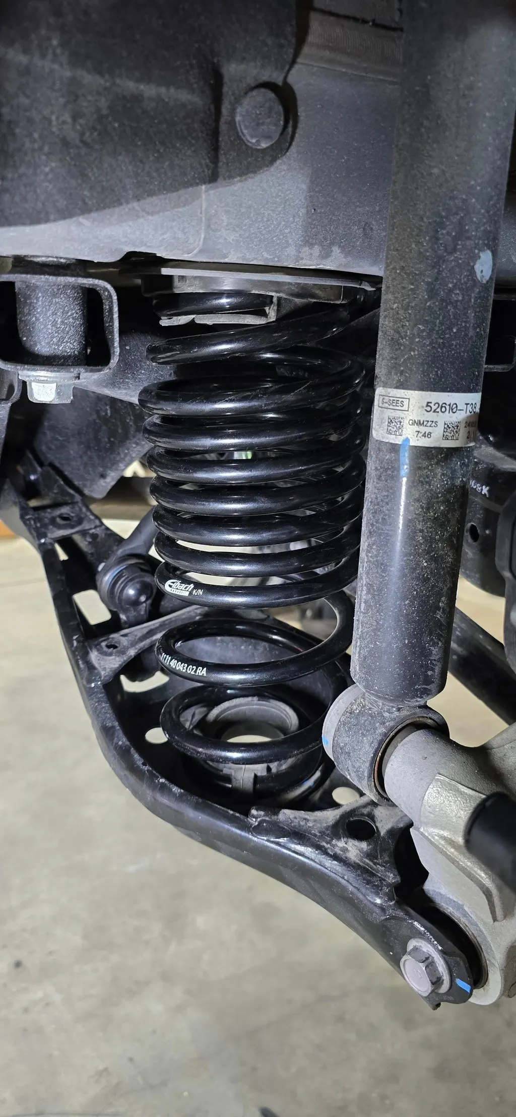Front coil spring and strut installed on a car at Juice Garage